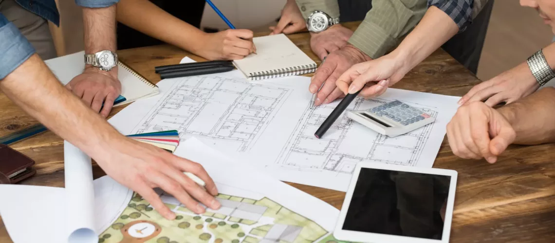 Businessmen and women doing discussion on blueprint in office